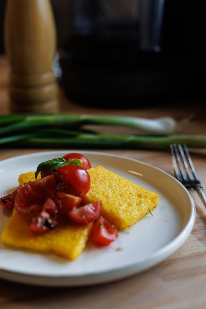 Knusprige Polentaschnitten aus dem Ofen mit frischem Tomatensalat